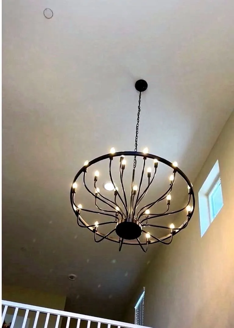 A chandelier hung in a double-height Sacramento entry, replacing a builder-grade fixture