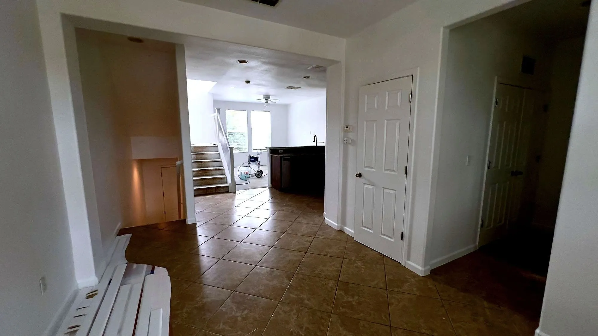Finished interior with new doors, trim and baseboards looking through to a kitchen