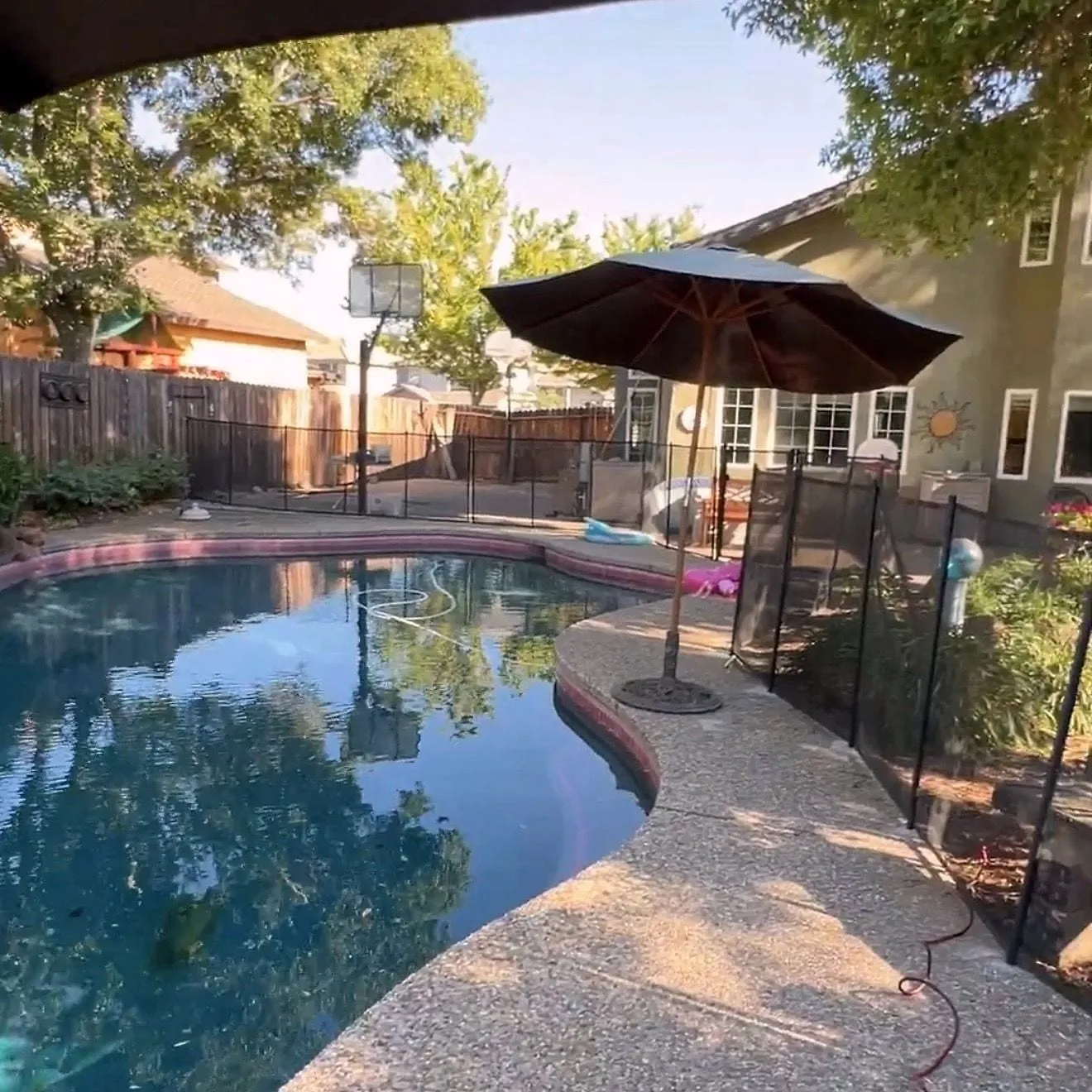 Black mesh pool safety fence installed along a Sacramento-area pool deck