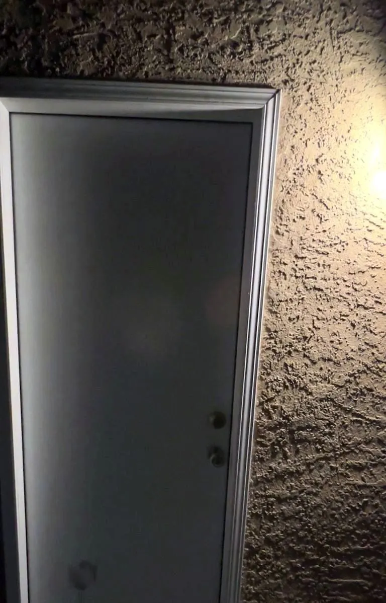 Exterior door hung square in a stucco opening.