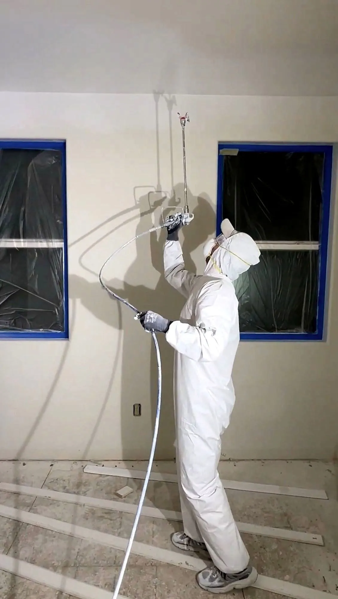Spray setup — masking and floor protection go in before anything else does.